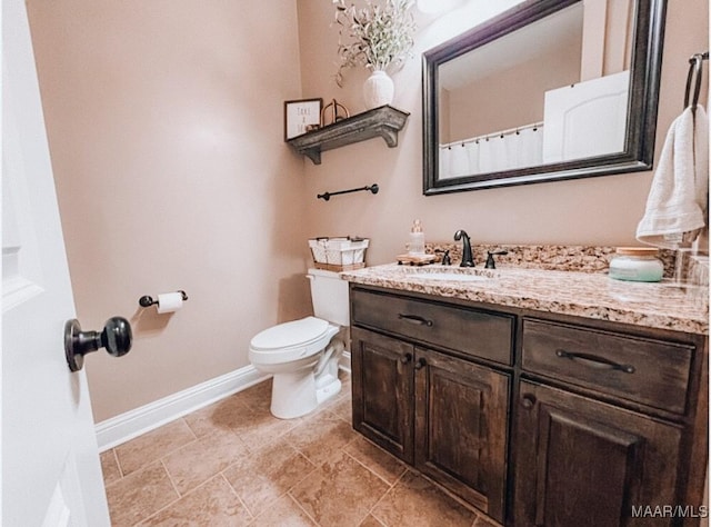 full bathroom featuring baseboards, vanity, and toilet