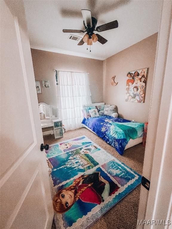 carpeted bedroom with visible vents and a ceiling fan