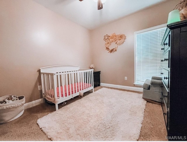 bedroom featuring a nursery area, carpet, and baseboards