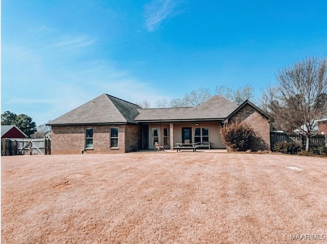 ranch-style home with brick siding, fence, and a patio