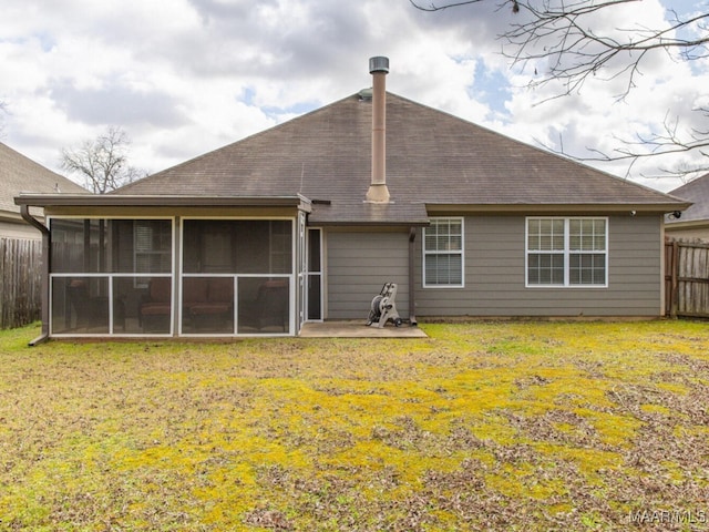 rear view of house with a sunroom, fence, a patio, and a yard