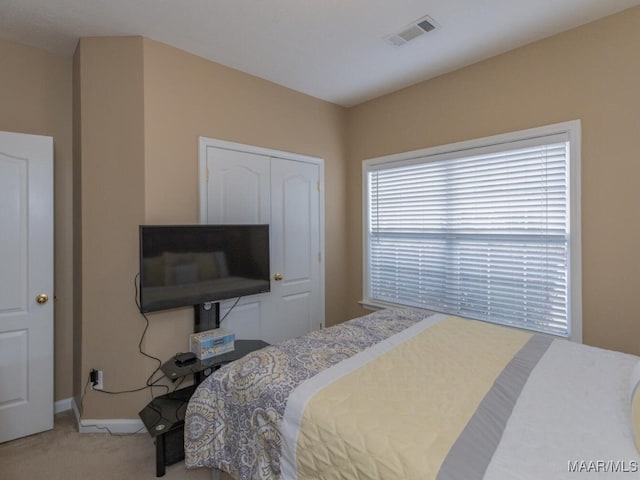 bedroom featuring baseboards, a closet, visible vents, and carpet flooring