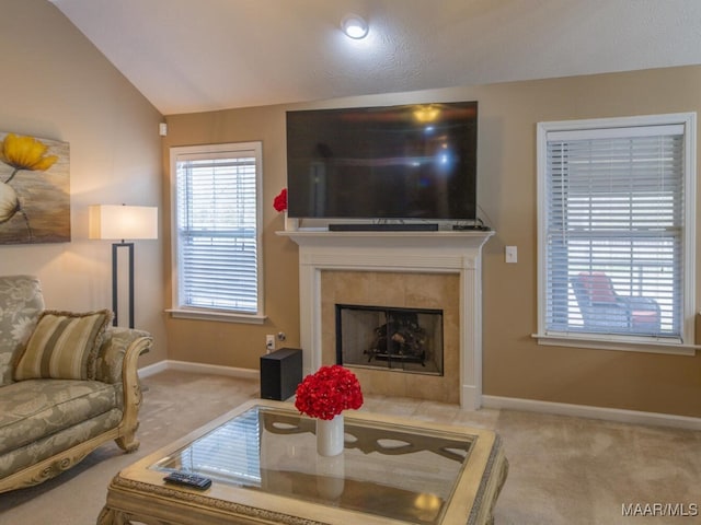 carpeted living area with lofted ceiling, a fireplace, and baseboards