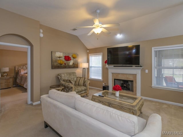 living area featuring lofted ceiling, a fireplace, visible vents, and carpet flooring