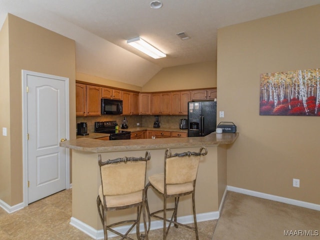 kitchen featuring visible vents, decorative backsplash, a peninsula, light countertops, and black appliances