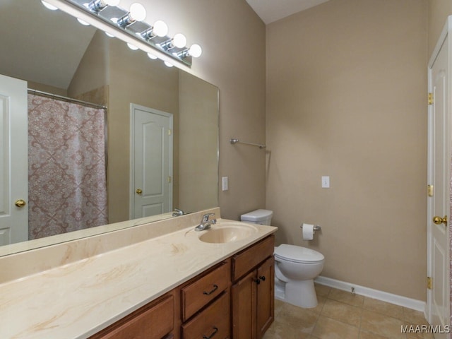 bathroom featuring baseboards, vanity, toilet, and tile patterned floors