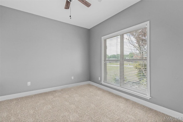 carpeted empty room featuring ceiling fan and baseboards