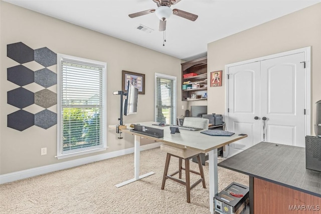 office space featuring carpet floors, visible vents, ceiling fan, and baseboards