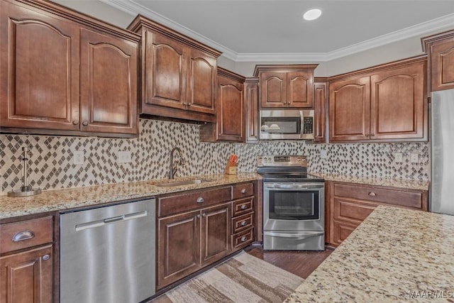 kitchen with dark wood-style floors, tasteful backsplash, appliances with stainless steel finishes, ornamental molding, and a sink