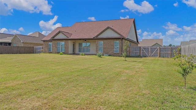 back of property featuring brick siding, a fenced backyard, and a yard