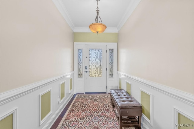 doorway to outside featuring ornamental molding, a wainscoted wall, and a decorative wall