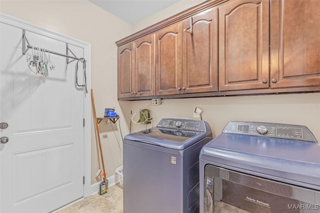 laundry room featuring independent washer and dryer, cabinet space, and baseboards