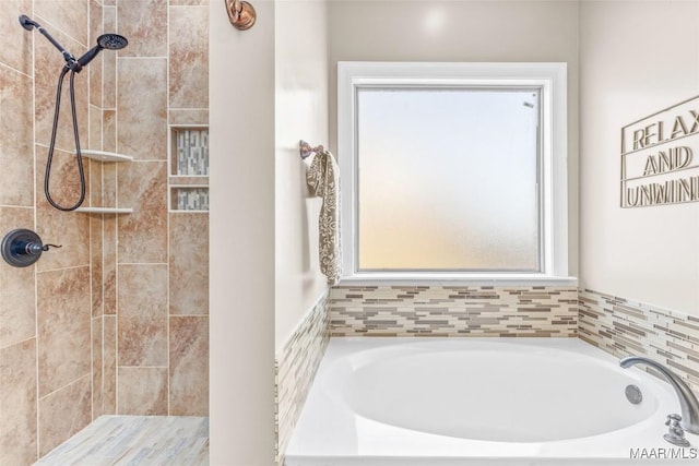 bathroom with a garden tub and a tile shower