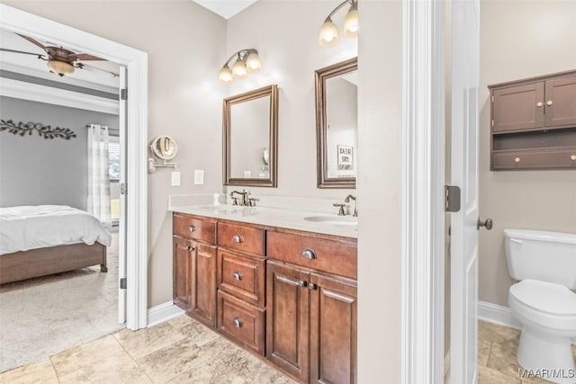 full bath featuring double vanity, connected bathroom, toilet, and a sink