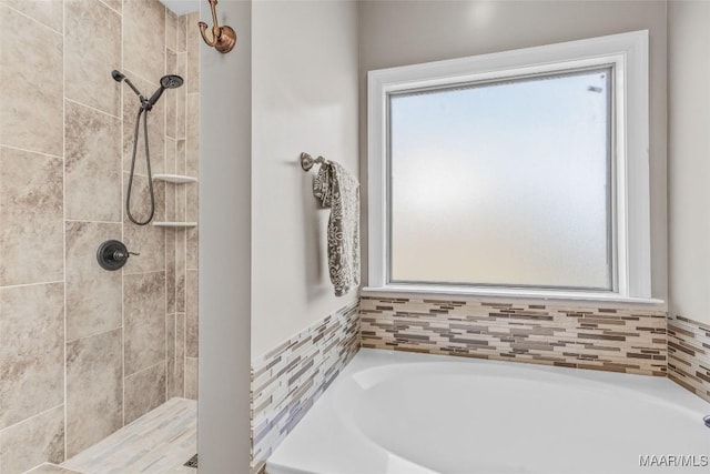 full bath featuring a tile shower and a bath