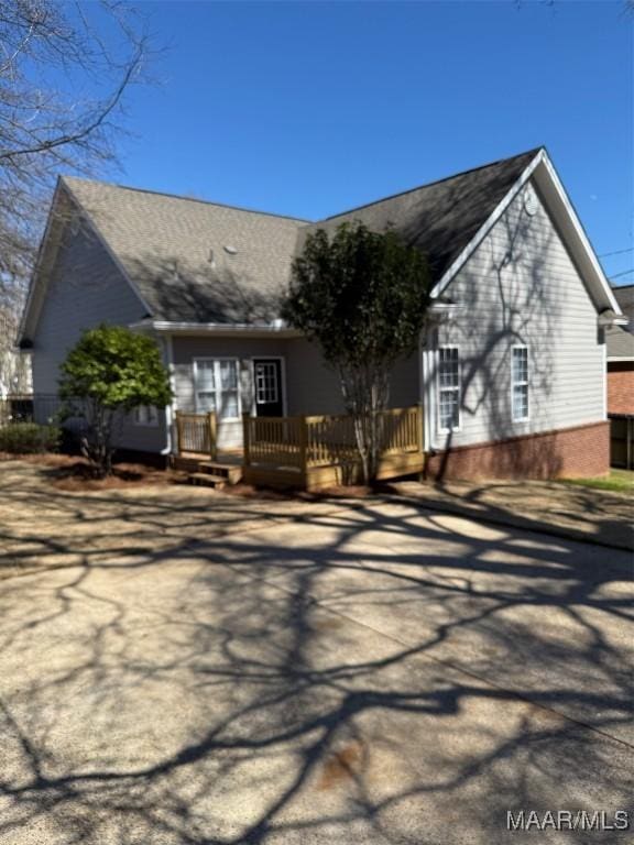 view of front of home with brick siding and a wooden deck