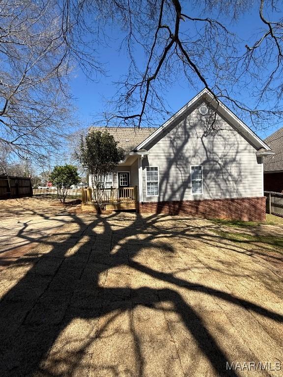 view of property exterior featuring fence and a deck