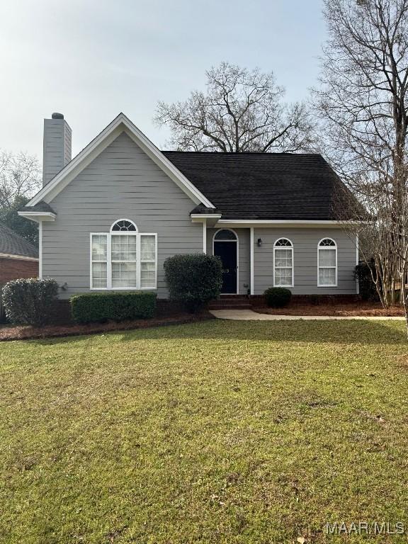 view of front facade with a front lawn and a chimney