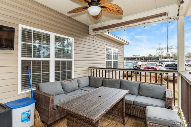 deck with an outdoor living space and a ceiling fan