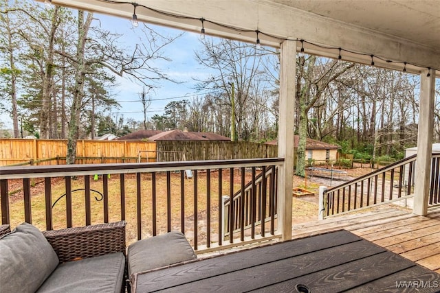 wooden terrace with a fenced backyard and an outdoor structure
