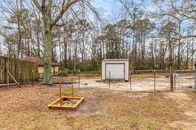 view of yard with a gate, fence, and an outbuilding