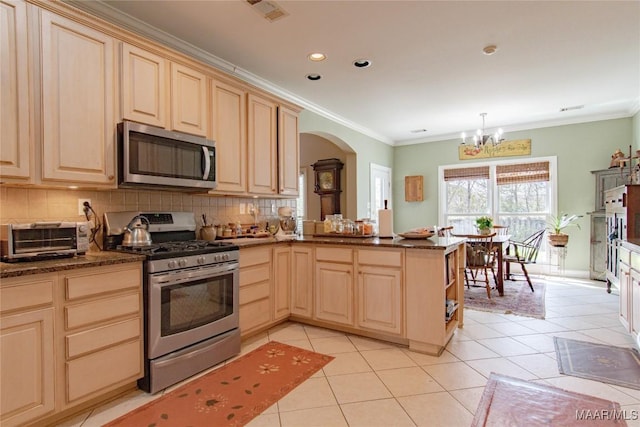 kitchen with light brown cabinetry, appliances with stainless steel finishes, and backsplash