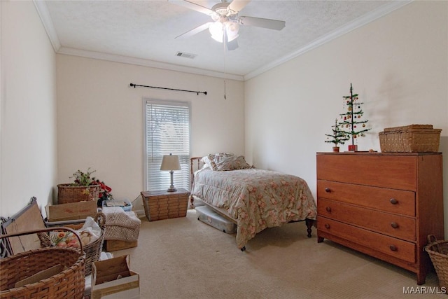 bedroom with carpet floors, visible vents, ornamental molding, a ceiling fan, and a textured ceiling