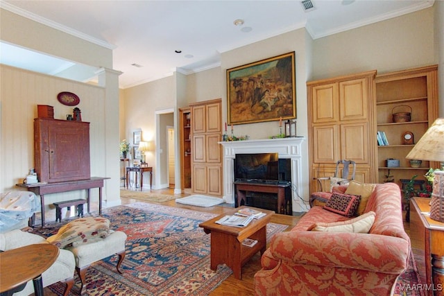 living room with decorative columns, visible vents, light wood-style flooring, ornamental molding, and a fireplace