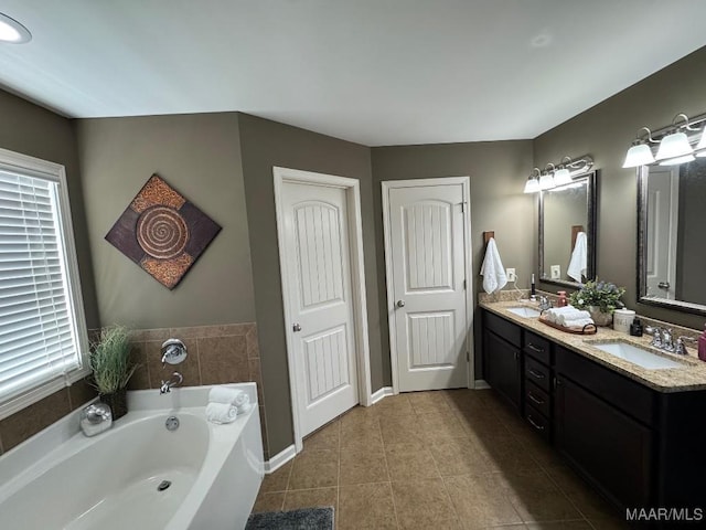 full bath with tile patterned floors, a garden tub, a sink, and double vanity