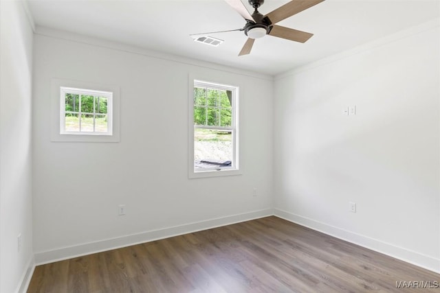 unfurnished room with visible vents, baseboards, ceiling fan, ornamental molding, and wood finished floors