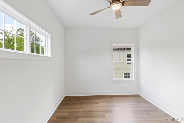 unfurnished room with a ceiling fan, baseboards, and wood finished floors