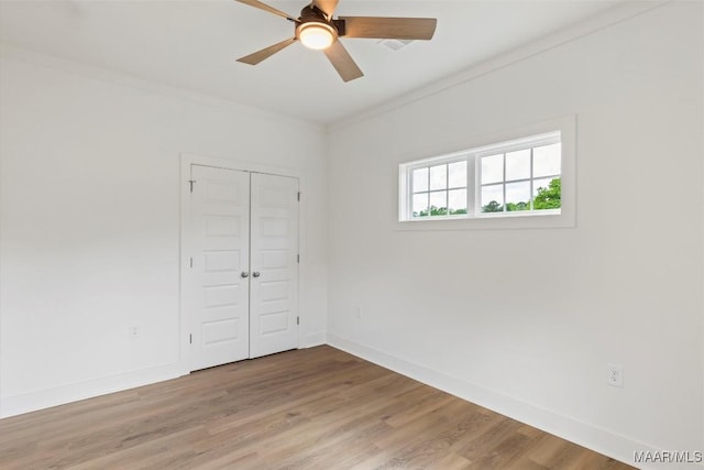 unfurnished room featuring ornamental molding, wood finished floors, a ceiling fan, and baseboards