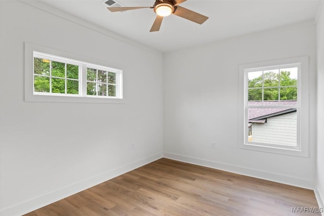 empty room with ceiling fan, baseboards, and wood finished floors