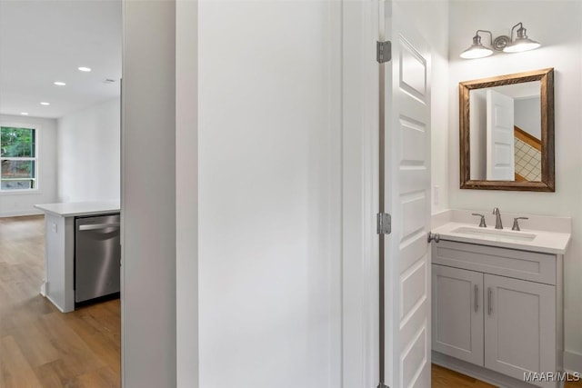 bathroom with recessed lighting, wood finished floors, and vanity