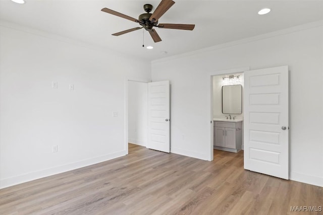 unfurnished bedroom featuring light wood finished floors, baseboards, crown molding, and recessed lighting