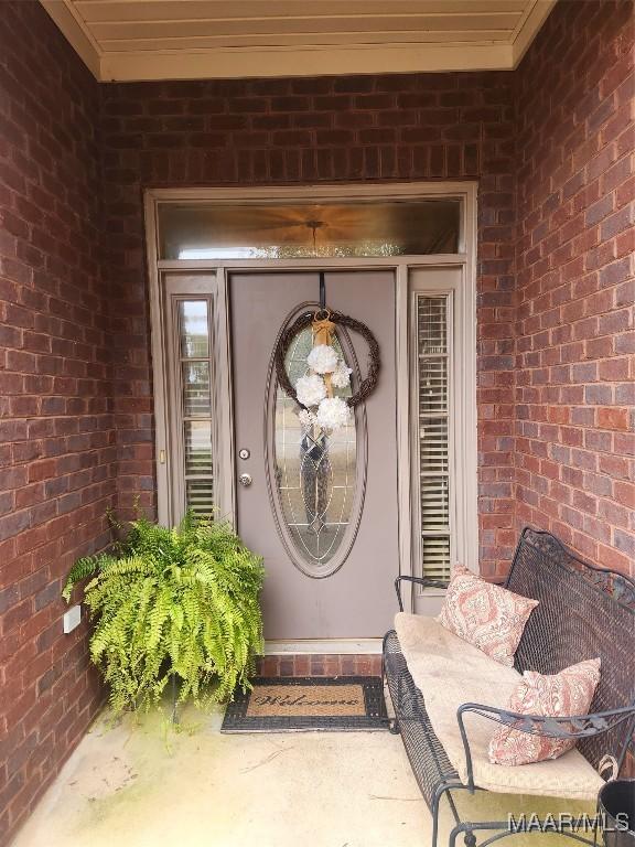 entrance to property featuring brick siding