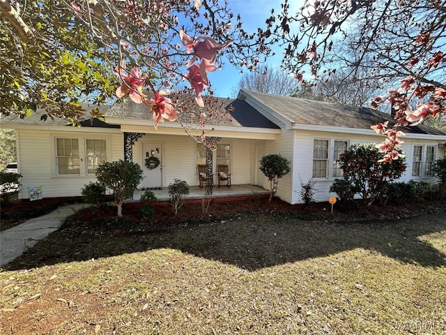 single story home featuring covered porch and a front lawn