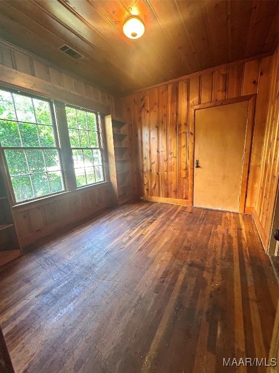 911 W Tuskeena St, Wetumpka, AL 36092 - empty room featuring wood walls, visible vents, hardwood / wood-style flooring, and wooden ceiling