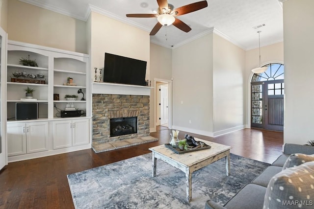 living room featuring a high ceiling, dark wood-style flooring, a fireplace, and visible vents