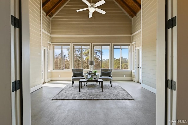 sunroom / solarium featuring vaulted ceiling with beams, wood ceiling, and a ceiling fan