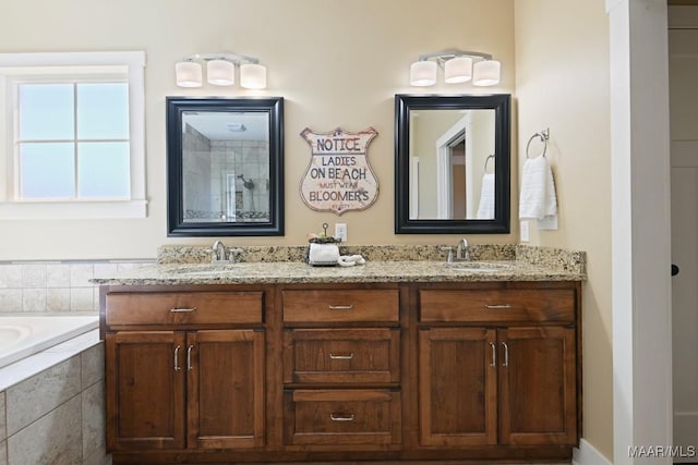 bathroom with tiled bath, a sink, and double vanity