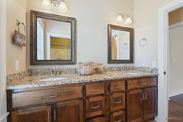 full bathroom with double vanity and a sink