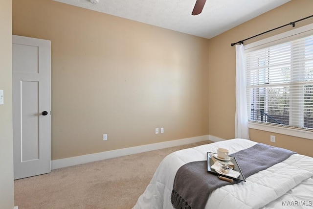 bedroom featuring a ceiling fan, carpet, a textured ceiling, and baseboards