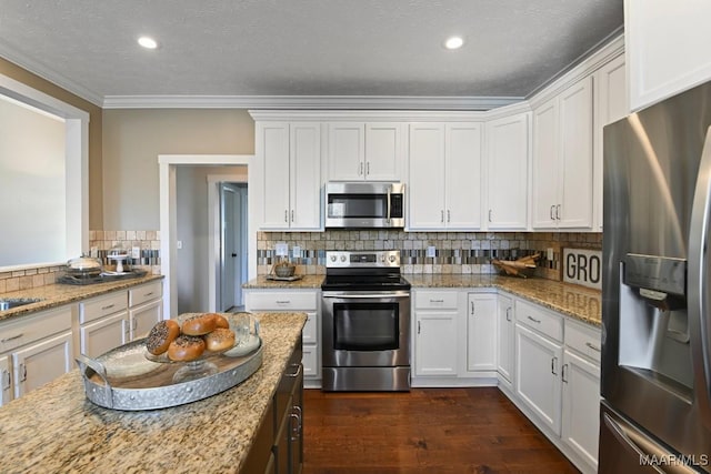 kitchen featuring appliances with stainless steel finishes, dark wood-type flooring, white cabinetry, and decorative backsplash