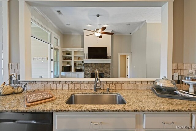 kitchen with visible vents, light stone counters, ornamental molding, a sink, and stainless steel dishwasher