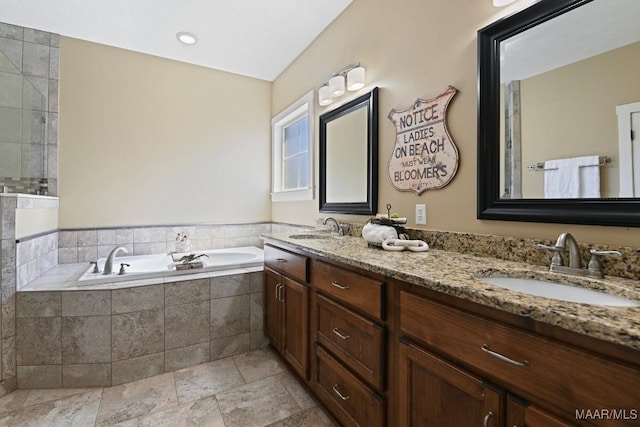 bathroom with double vanity, a garden tub, and a sink