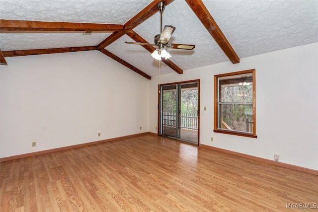 spare room featuring light wood-type flooring, baseboards, a textured ceiling, and lofted ceiling with beams