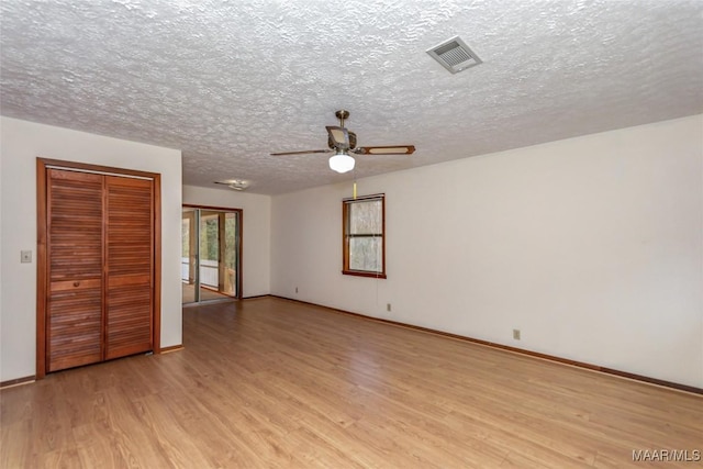 unfurnished bedroom featuring light wood-type flooring, baseboards, visible vents, and a textured ceiling