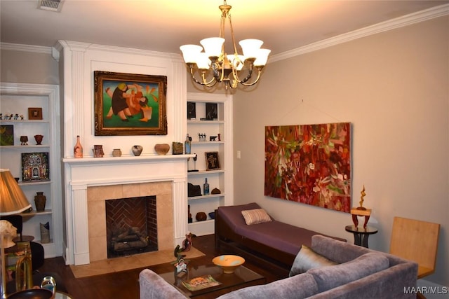 living room with built in features, visible vents, crown molding, a fireplace, and a chandelier