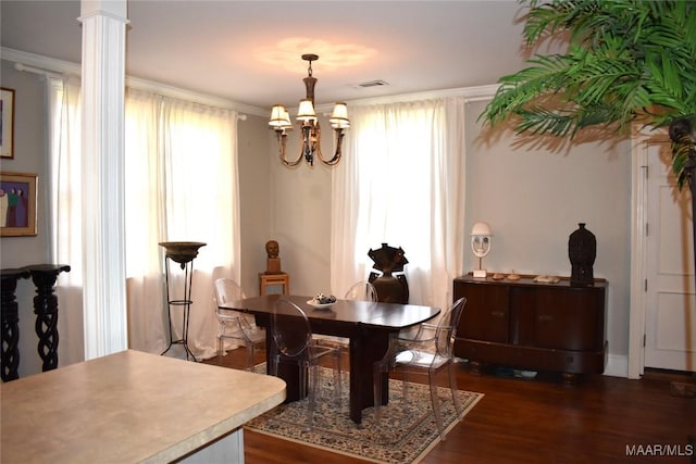 dining room featuring visible vents, ornamental molding, wood finished floors, ornate columns, and a chandelier